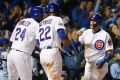 Big lead: Javier Baez celebrates with Dexter Fowler and Jason Heyward after sliding safely into home.