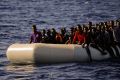 Migrants fleeing Libya on a dinghy wait to be rescued in the Mediterranean Sea.