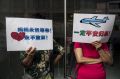 Chinese relatives of missing passengers  hold signs, one reading "Mama waits for you, Never Give Up", left, and "Must ...