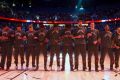 Toronto Raptors players lock arms during the singing of the national anthems.