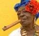 A Cuban woman, in traditional colonial costume, with a famous Cuban cigar in Old Havana.