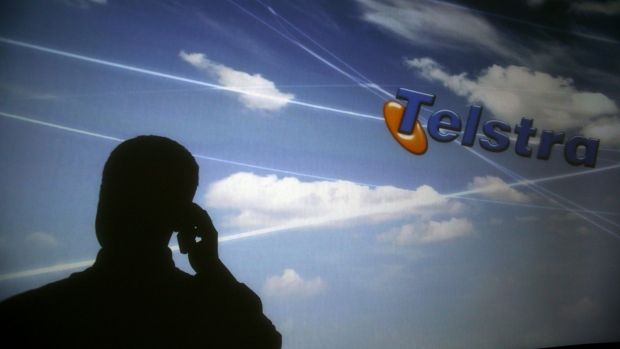 Man on mobile phone silhouetted on a Telstra screen. generic, telephone, broadband, shadow. Monday 15th December 2008 AFR photo Louie Douvis AFR USE ONLY SPECIAL 97924 clouds