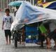 A market stall owner takes shelter on a promenade in Manila on Sunday.