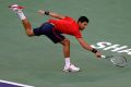 Stretched: Novak Djokovic return against Roberto Bautista Agut of Spain.