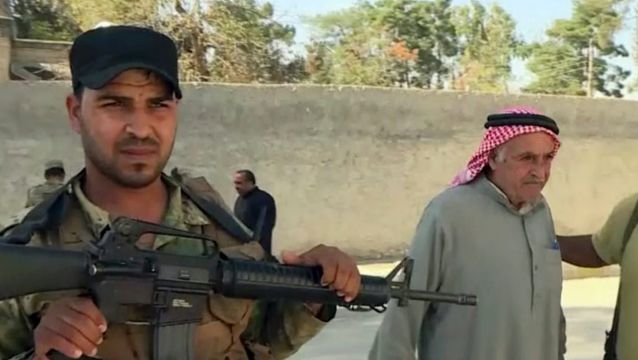 Turkish-backed Syrian opposition forces allow a man to pass after being searched in Dabiq, Syria.