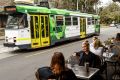 The number 8 tram passes a cafe on Domain Road.