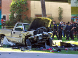 Police stand near the pickup truck that landed at Chicano Park after it flew off a ramp to the San Diego Coronado Bridge in San Diego on Saturday, Oct. 15, 2016.  Four people were killed and nine were injured on Saturday after an out-of-control pickup truck plunged off the San Diego-Coronado Bridge and plowed into crowd gathered at a festival below, authorities said.   (Hayne Palmour IV/The San Diego Union-Tribune via AP)