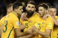 No venue switch: Skipper Mile Jedinak is congratulated by teammates after his penalty against Japan. 

