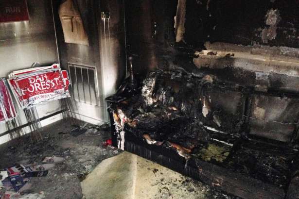 A burned couch is shown next to warped campaign signs at the Orange County Republican Headquarters in Hillsborough, NC on Sunday, Oct. 16 2016. Someone threw flammable liquid inside a bottle through a window overnight and someone spray-painted an anti-GOP slogan referring to "Nazi Republicans" on a nearby wall, authorities said Sunday. State GOP director Dallas Woodhouse said no one was injured.