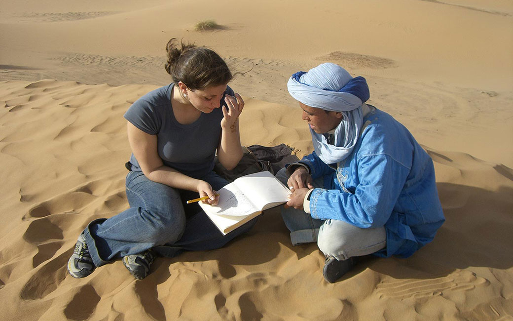 two people in sand studying