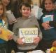 Christopher Cornelius holds the 'Thank You' sign in the center of this photo.