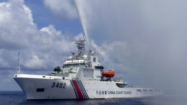 A Chinese Coast Guard boat sprays a water cannon at Filipino fishermen near Scarborough Shoal in the South China Sea ...