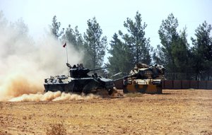 A Turkish army tank and an armored vehicle are stationed near the border with Syria, in Karkamis, Turkey, Tuesday, Aug. 23, 2016. Turkish media reports say Turkish artillery on Tuesday launched new strikes at Islamic State targets across the border in Syria.