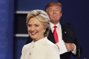 Democratic presidential nominee Hillary Clinton walks off stage as Republican presidential nominee Donald Trump puts his notes away after the third presidential debate at UNLV in Las Vegas, Wednesday, Oct. 19, 2016.