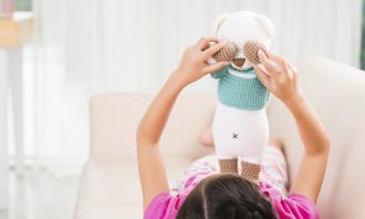 Girl playing with toy bear