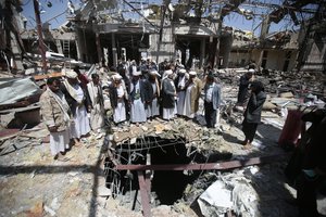 In this Thursday, Oct. 13, 2016 file photo, members of the Higher Council for Civilian Community Organization inspect a destroyed funeral hall as they protest against a deadly Saudi-led airstrike on a funeral hall six days ago, in Sanaa, Yemen.