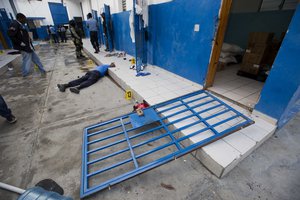 A guard lies dead inside the Civil Prison after a jail break in the coastal town of Arcahaiea, Haiti, Saturday, Oct. 22, 2016.