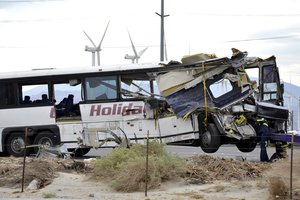 Workers prepare to haul away a tour bus that crashed with semi-truck on Interstate 10 just west of the Indian Canyon Drive off-ramp, in Desert Hot Springs, Calif., near Palm Springs, Calif., on Sunday, Oct. 23, 2016. Several deaths and injuries were reported. (AP Photo/Rodrigo Peña)