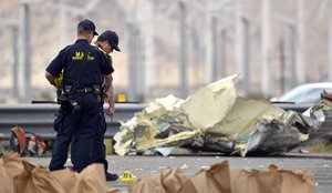 Investigators mark pieces of evidence after a tour bus crashed with a semi-truck on Interstate 10 just west of the Indian Canyon Drive off-ramp, in Desert Hot Springs, Calif., near Palm Springs, Calif., on Sunday, Oct. 23, 2016.