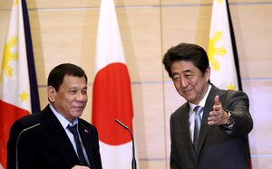 Philippine President Rodrigo Duterte, left, is escorted by Japan's Prime Minister Shinzo Abe, right, after a joint press conference at the prime minister's office in Tokyo, Wednesday, Oct. 26, 2016.