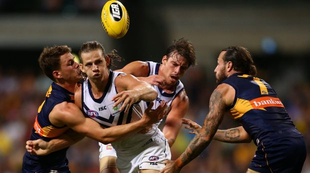 Nathan Fyfe of the Dockers gets a handball away as he is tackled by Jack Redden of the Eagles.