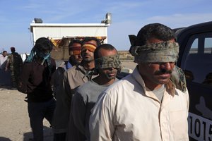 Suspected members of the Islamic State group wait to be taken for interrogation after being found among civilians returning to Ramadi for the first time since the city was taken back by Iraqi government forces earlier this year, in Ramadi, Iraq, Sunday, April 3, 2016.