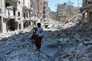 In This April 21, 2014, file photo, provided by the anti-government activist group Aleppo Media Center (AMC), which has been authenticated based on its contents and other AP reporting, shows a Syrian man holding a girl as he stands on the rubble of houses that were destroyed by Syrian government forces air strikes in Aleppo, Syria.