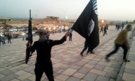 A fighter of the Islamic State holds an IS flag on a street in the city of Mosul in June 23, 2014. Photo: Reuters/Stringer