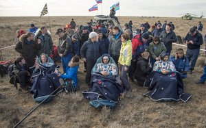 NASA astronaut Kate Rubins, left, Russian cosmonaut Anatoly Ivanishin of Roscosmos, center, and astronaut Takuya Onishi of the Japan Aerospace Exploration Agency (JAXA) sit in chairs outside the Soyuz MS-01 spacecraft a few moments after they landed in a remote area near the town of Zhezkazgan, Kazakhstan on Sunday, Oct. 30, 2016.