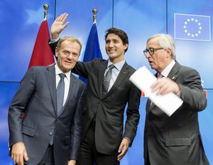 European Council President Donald Tusk, left, Canadian Prime Minister Justin Trudeau, center, and European Commission President Jean-Claude Juncker prepare to leave the room at the end of an EU-Canada summit at the European Council building in Brussels, Sunday, Oct. 30, 2016.