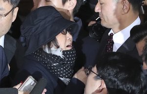 Choi Soon-sil, center left, a cult leader's daughter with a decades-long connection to President Park Geun-hye, is surrounded by prosecutor's officers and media upon her arrival at the Seoul Central District Prosecutors' Office in Seoul, South Korea