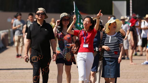 A tour guide leads a group of tourists towards the Sydney Opera House in Sydney: Australia needs to lift its game if it ...