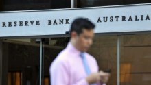 Man walks past Reserve Bank building in Sydney