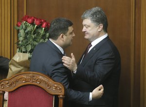 In this Thursday, April 14, 2016 file photo Ukraine's President Petro Poroshenko, right, and Prime Minister Volodymyr Groysman celebrate after Groysman was appointed the Prime Minister during the Ukrainian parliament session in Kiev, Ukraine. Late Sunday, Oct. 30 2016, was the deadline by which all Ukrainian officials were due to declare assets.