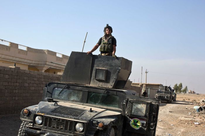 An Iraqi special forces soldier stands atop a Humvee in the village of Bazwaia.