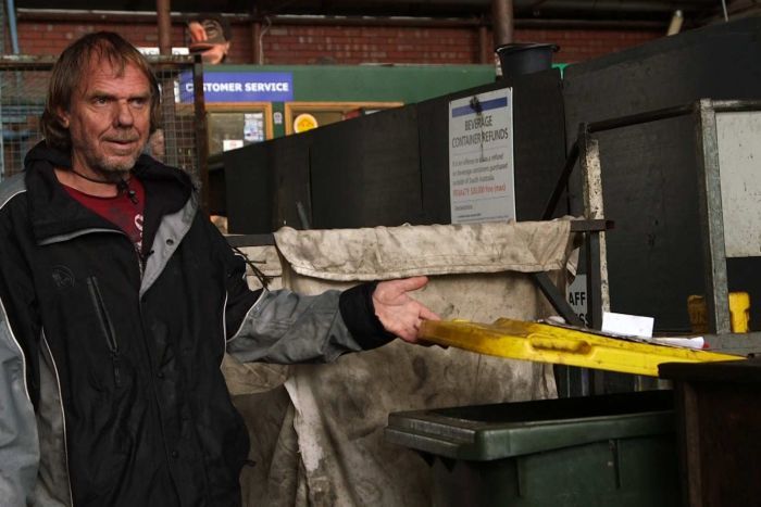 Kevin lifting the lid of a bin at the recycling depot in Adelaide.