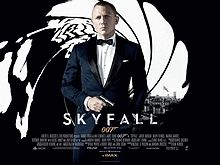 The poster shows James Bond wearing a tuxedo and holding a gun, standing in front of an image that looks like it was taken from the inside of a gun barrel, with the London skyline visible behind him. Text at the bottom of the poster reveals the film title and credits.