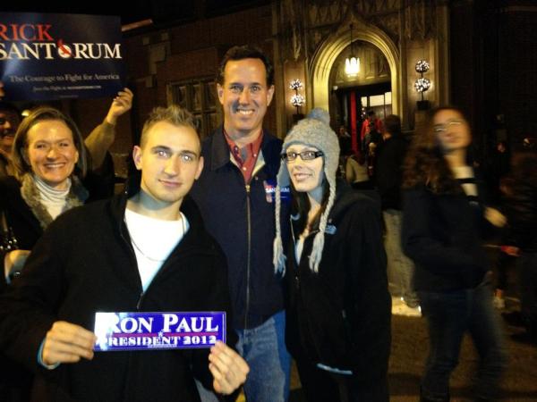 Anthony Grina in 2012 photobombs then-Presidential Candidate Rick Santorum with a bumper sticker for the candidate he actually supported.