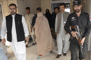 Pakistani officials escort Netgeo famed Afghan woman Sharbat Gulla in burqa or veil outside a court in Peshawar, Pakistan, Friday, Nov. 4, 2016.