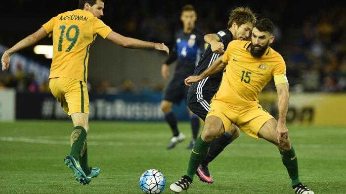 Genki Haraguchi of Japan (centre) and Mile Jedinak of Australia (right) contest during the 2018 FIFA World Cup Qualifier game between Australia and Japan at Etihad Stadium in Melbourne, Tuesday, Oct. 11, 2016. (AAP Image/Julian Smith) NO ARCHIVING, EDITORIAL USE ONLY