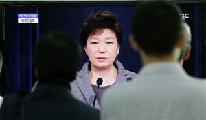 People watch a live television program showing South Korean President Park Geun-hye's speech to the nation regarding the sunken ferry Sewol at the Seoul Train Station in Seoul, South Korea, Monday, May 19, 2014.