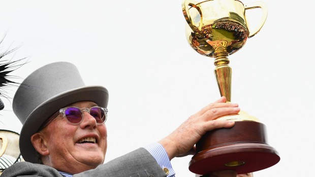 Lloyd Williams holds up the Melbourne Cup.