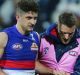 Tom Liberatore is helped from the ground after injuring his ankle against Geelong.