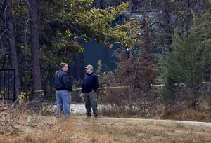 Law enforcement personnel stand near police tape on Todd Kohlhepp's property in Woodruff, S.C. Sunday, Nov. 6, 2016.