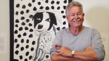 Ken Done stands before one his painting at the National Portrait Gallery in Canberra.