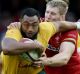 Tevita Kuridrani is tackled by Wales Ken Owens and Bradley Davies.