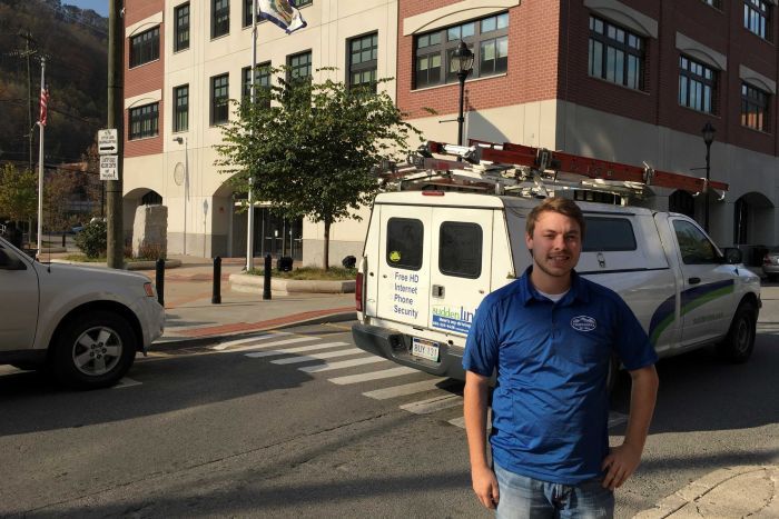 Logan County resident Trevor Bryant stands in front of a brick building in West Virginia.