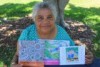 Indigenous Elder Nicky Hatfield with the three books she's written in Darumbal language