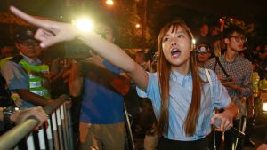 Newly elected Hong Kong lawmaker Yau Wai-ching, shouts at police officers after clashing as thousands of people march in ...