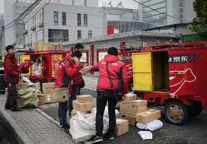 Workers sort parcels for their customers near the JD.com delivery bikes during the "Singles' Day" online shopping festival, in Beijing, China, Wednesday, Nov. 11, 2015. Alibaba registered record-breaking Singles' Day sales numbers.